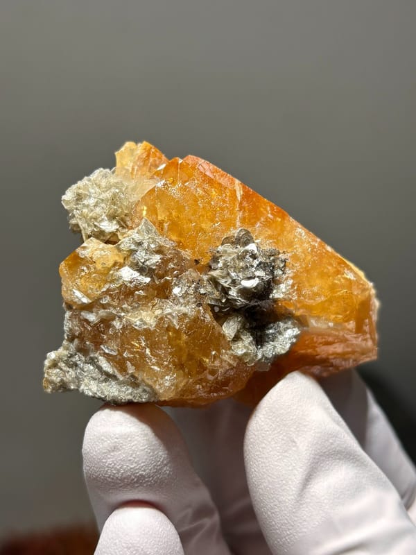 Orange scheelite cluster with mica from Xuebaoding, Sichuan, China, close-up of the crystal faces