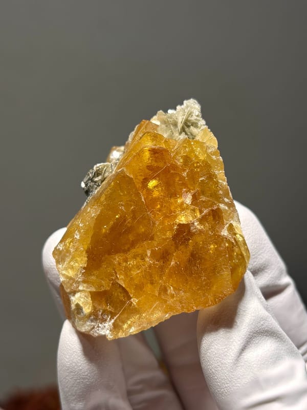 Orange scheelite cluster with mica from Xuebaoding, Sichuan, China, reverse side