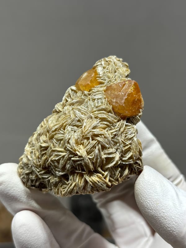 Orange scheelite crystals on tan mica block from Xuebaoding, Sichuan, China, second angle