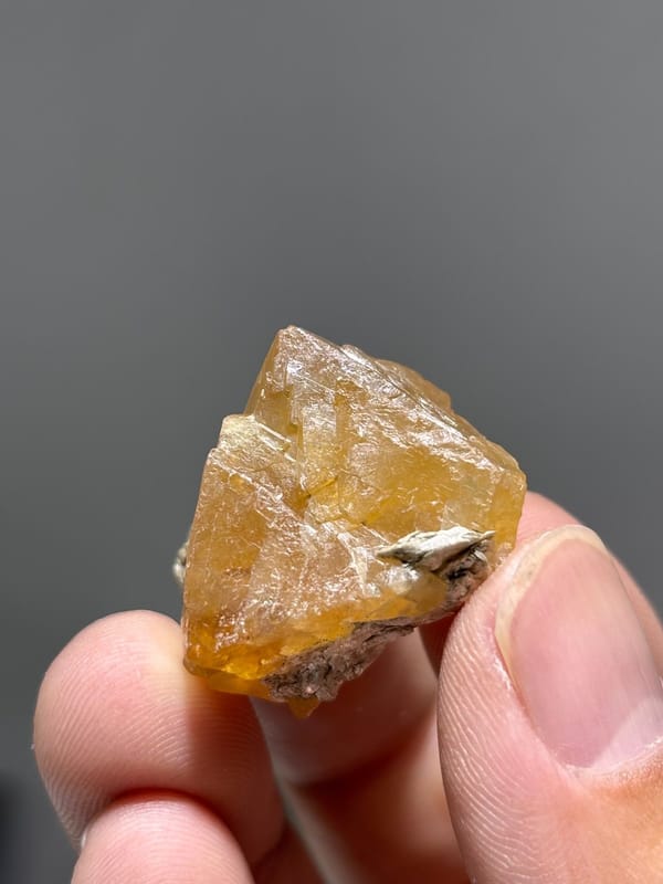 Orange scheelite floater crystal from Xuebaoding, Sichuan, China, view 5 of 5