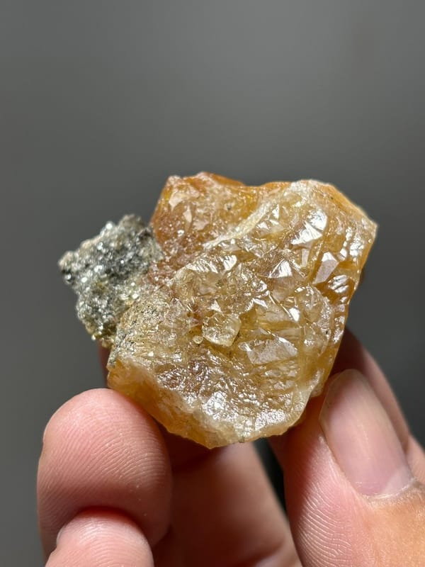Orange scheelite with grey mica patch from Xuebaoding, Sichuan, China, view 2 of 5