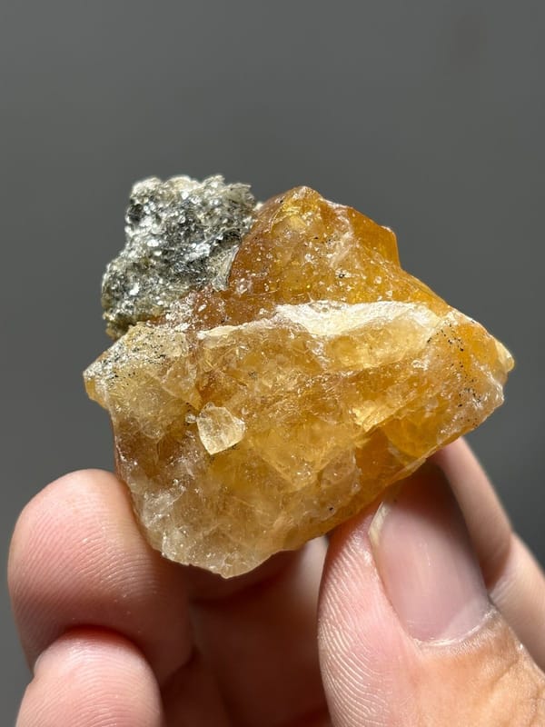 Orange scheelite with grey mica patch from Xuebaoding, Sichuan, China, view 3 of 5