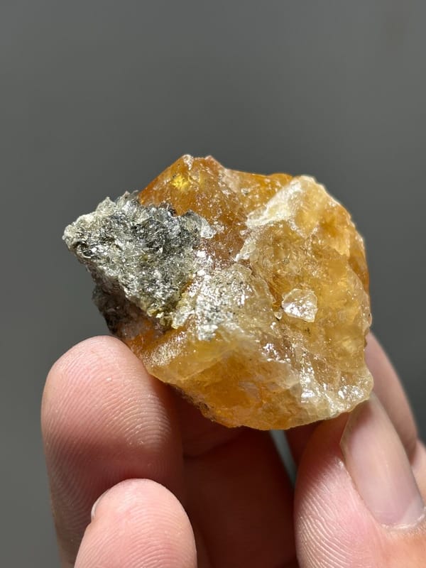 Orange scheelite with grey mica patch from Xuebaoding, Sichuan, China, view 4 of 5