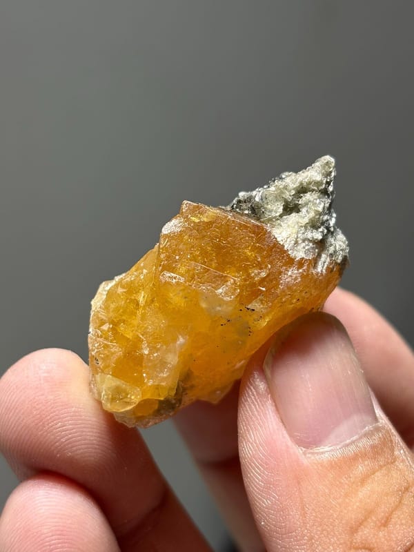 Orange scheelite with grey mica patch from Xuebaoding, Sichuan, China, view 5 of 5