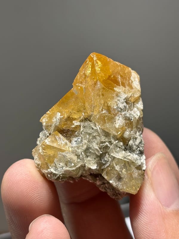 Orange scheelite crystals with white mica from Xuebaoding, Sichuan, China, view 3 of 7