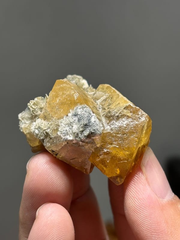 Orange scheelite crystals with white mica from Xuebaoding, Sichuan, China, view 6 of 7