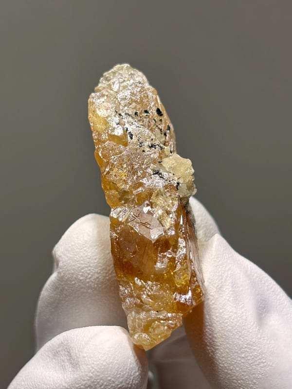 Orange scheelite floater from Xuebaoding, Sichuan, China, view 4 of 5