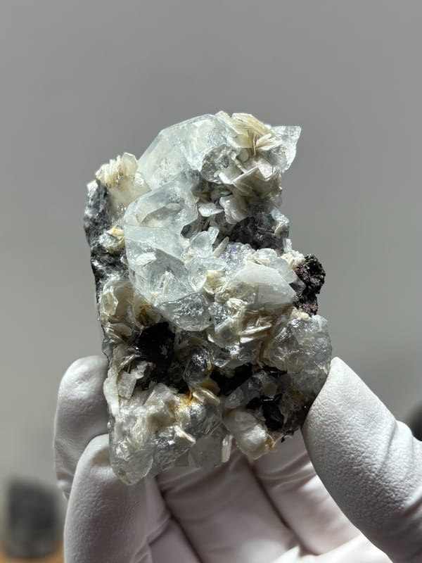 Pale aquamarine with black cassiterite and mica from Xuebaoding, Sichuan, China, close-up of the crystal faces