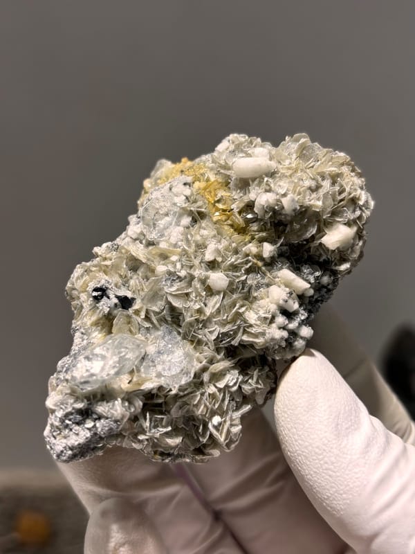 Pale aquamarine with black cassiterite, mica and feldspar from Xuebaoding, Sichuan, China, close-up of the crystal faces