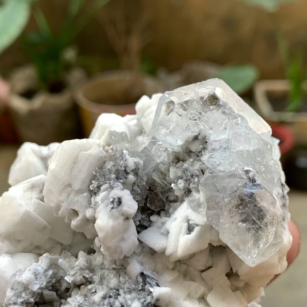 Pale aquamarine crystal on white feldspar with mica from Xuebaoding, Sichuan, China, top view