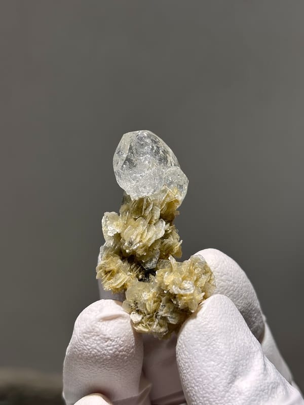 Pale aquamarine crystal on golden mica stalk from Xuebaoding, Sichuan, China, close-up of the crystal faces