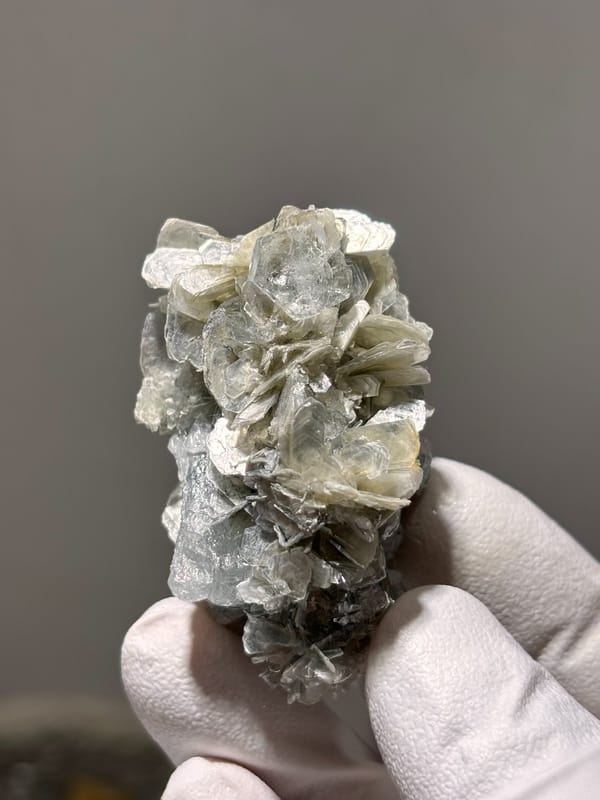 Pale aquamarine crystal capping tan mica stack from Xuebaoding, Sichuan, China
