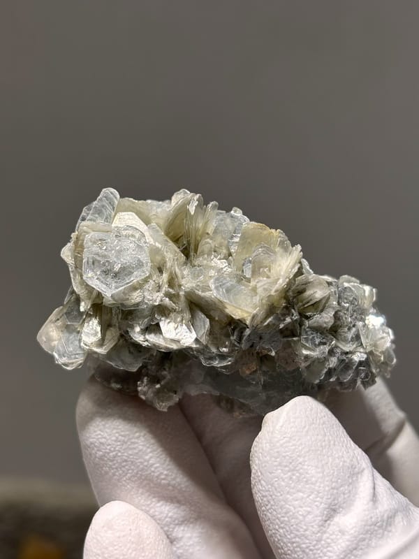 Pale aquamarine crystal capping tan mica stack from Xuebaoding, Sichuan, China, view 2 of 5