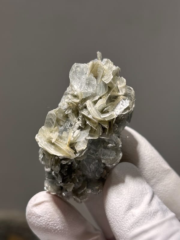 Pale aquamarine crystal capping tan mica stack from Xuebaoding, Sichuan, China, view 4 of 5