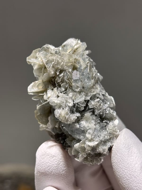 Pale aquamarine crystal capping tan mica stack from Xuebaoding, Sichuan, China, view 5 of 5