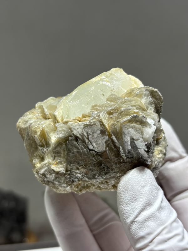 Pale aquamarine crystal nested in mica blades and feldspar from Xuebaoding, Sichuan, China, close-up of the crystal faces