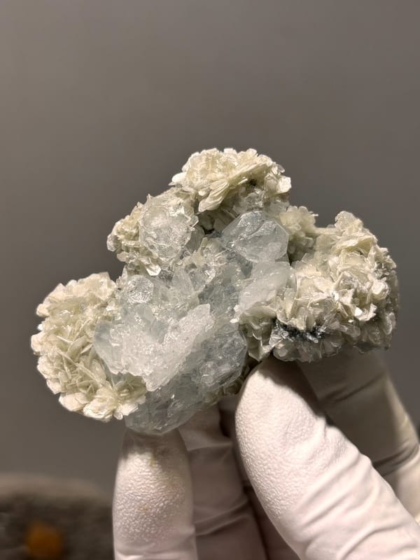 Pale aquamarine block ringed with tan mica rosettes from Xuebaoding, Sichuan, China