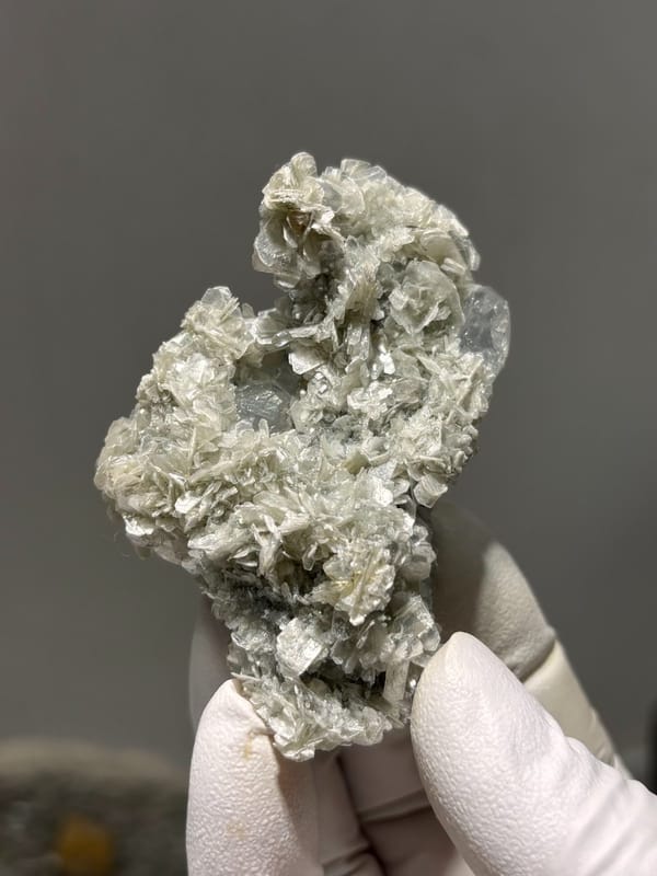 Pale aquamarine block ringed with tan mica rosettes from Xuebaoding, Sichuan, China, view 5 of 6