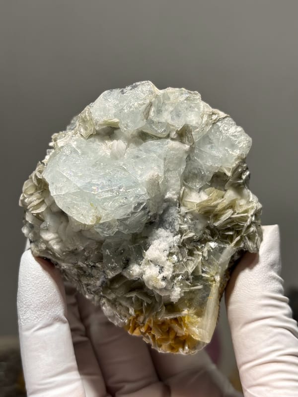 Pale aquamarine cluster with mica, feldspar and cassiterite from Xuebaoding, Sichuan, China, close-up of the crystal faces