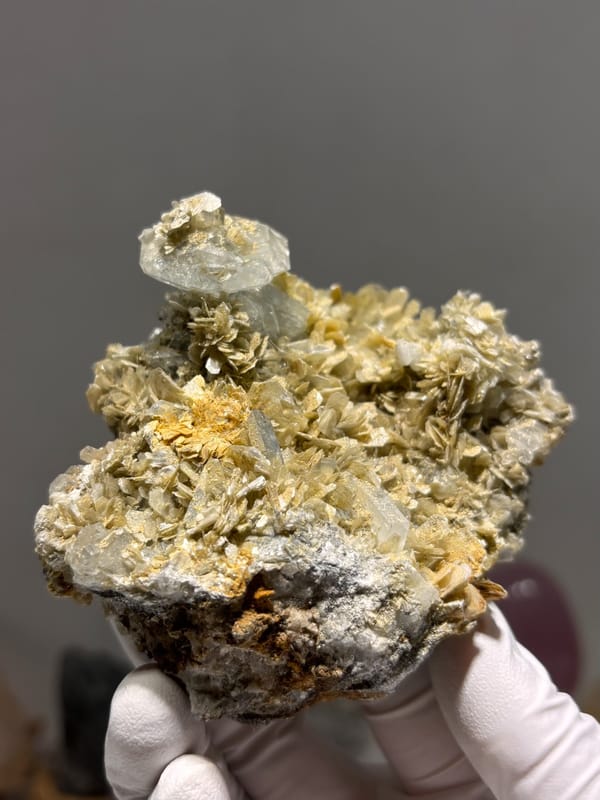 Pale aquamarine crystal atop golden mica rosette plate from Xuebaoding, Sichuan, China, second angle