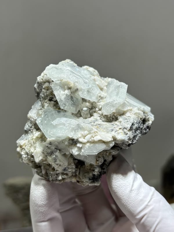 Pale blue aquamarine crystals on white feldspar from Xuebaoding, Sichuan, China, close-up of the crystal faces