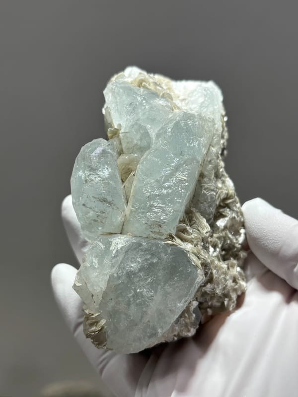Pale blue aquamarine crystals over grey mica from Xuebaoding, Sichuan, China, close-up of the crystal faces