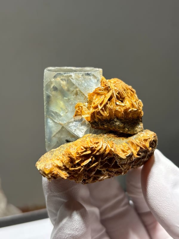 Pale green fluorite octahedron on golden mica from Xuebaoding, Sichuan, China, detail of the matrix contact