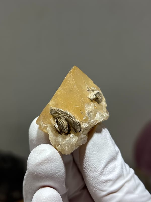 Pale honey scheelite crystal with mica from Xuebaoding, Sichuan, China, close-up of the crystal faces