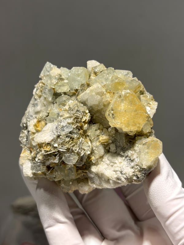 Pale yellow aquamarine crystals on mica and feldspar from Xuebaoding, Sichuan, China, close-up of the crystal faces