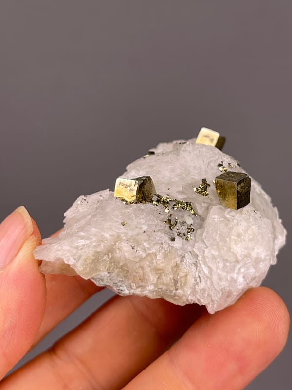White matrix with sharp pyrite cubes visible on petal-form calcite specimen from Longyan, Fujian, China