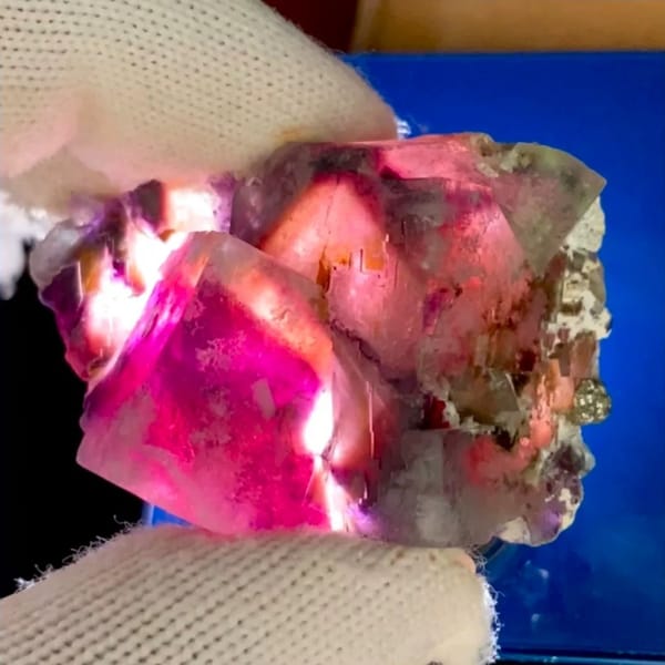 Phantom fluorite glowing magenta when, from Inner Mongolia, China, front view in daylight, view 2 of 9
