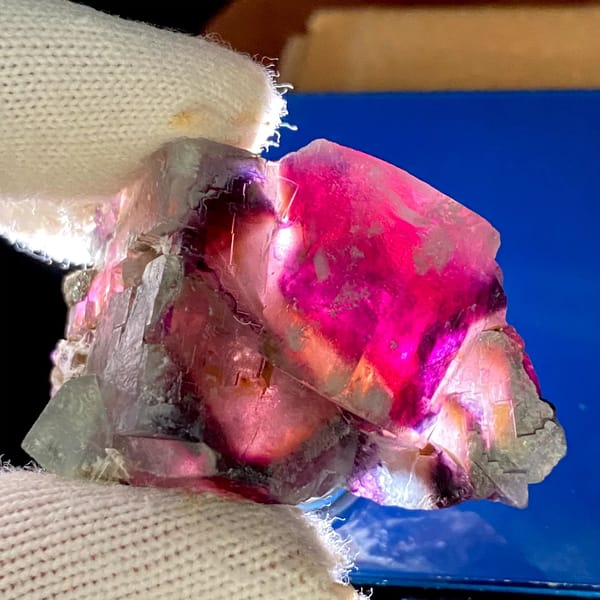 Phantom fluorite glowing magenta when, from Inner Mongolia, China, front view in daylight, view 6 of 9