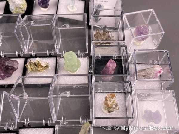 Bulk002 actual mixed mineral specimen box with approximately 35 to 40 different mini specimens in clear display boxes, including likely fluorite, quartz, aquamarine, galena, pyrite, grape agate, stibnite and other assorted minerals.