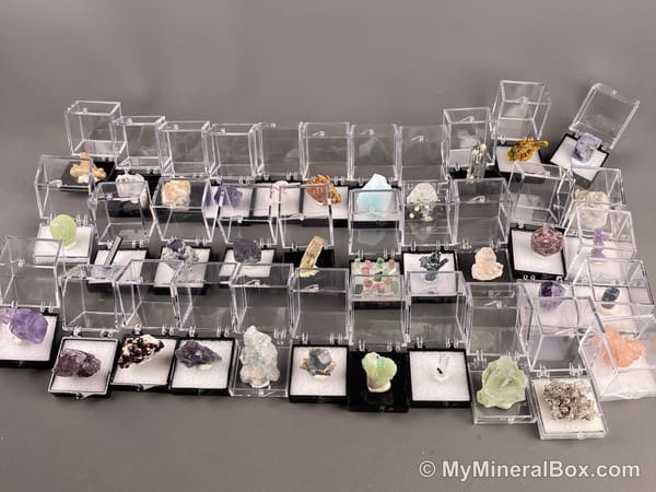 Bulk003 actual mixed mineral specimen box with about 35 different mini natural specimens, including likely fluorite, garnet, stibnite, quartz, aquamarine, tourmaline and grape agate.