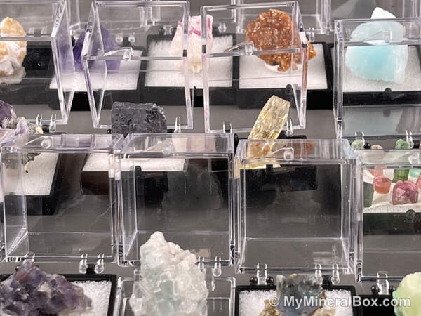 Bulk003 actual mixed mineral specimen box with about 35 different mini natural specimens, including likely fluorite, garnet, stibnite, quartz, aquamarine, tourmaline and grape agate.