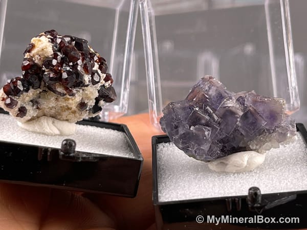 Bulk003 actual mixed mineral specimen box with about 35 different mini natural specimens, including likely fluorite, garnet, stibnite, quartz, aquamarine, tourmaline and grape agate.