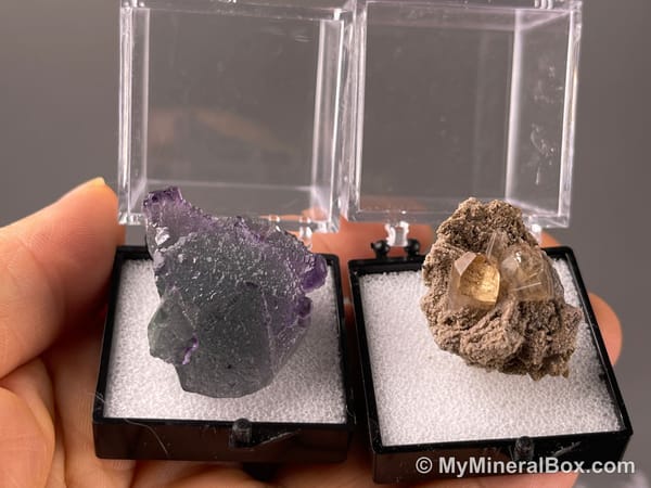 Bulk004 actual mixed mineral specimen box with about 35 different mini natural specimens, including likely fluorite, black tourmaline, quartz, stibnite, grape agate and green prehnite-type material.
