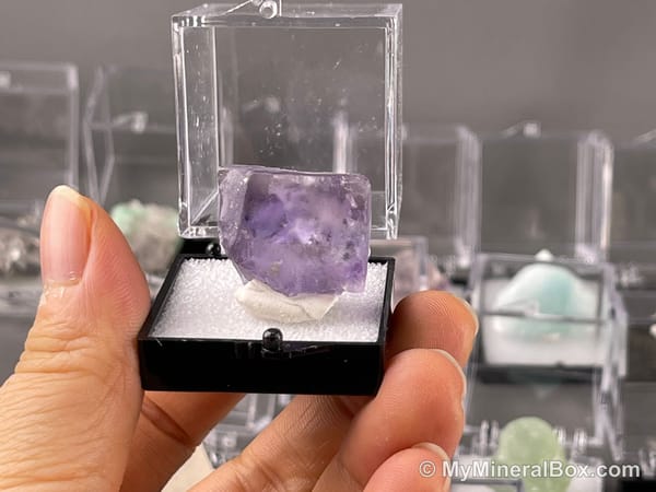 Bulk004 actual mixed mineral specimen box with about 35 different mini natural specimens, including likely fluorite, black tourmaline, quartz, stibnite, grape agate and green prehnite-type material.