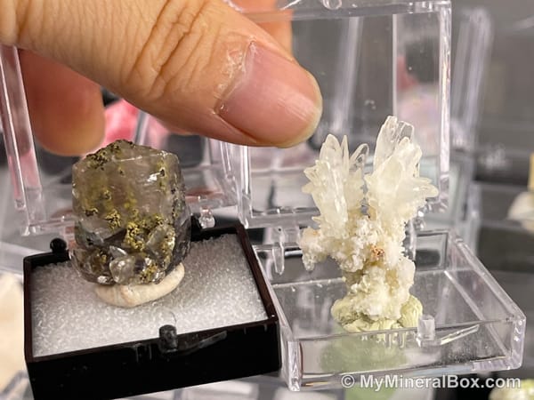 Bulk004 actual mixed mineral specimen box with about 35 different mini natural specimens, including likely fluorite, black tourmaline, quartz, stibnite, grape agate and green prehnite-type material.