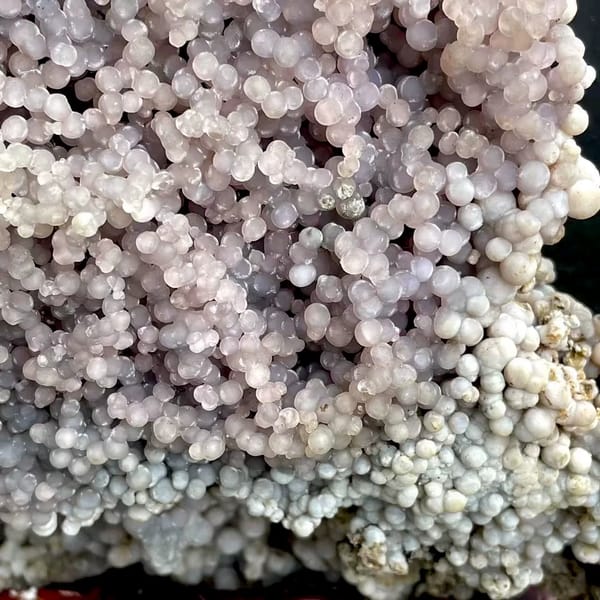 Tall tower of pearly lavender grape agate on stand from Indonesia, close-up of the crystal faces