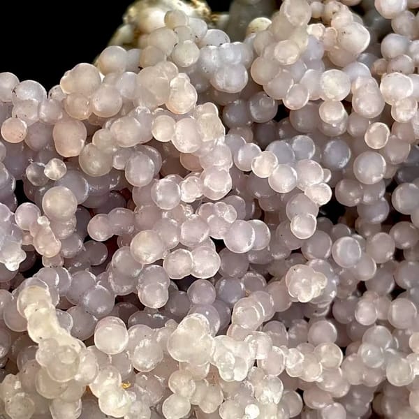 Tall tower of pearly lavender grape agate on stand from Indonesia, detail of the matrix contact