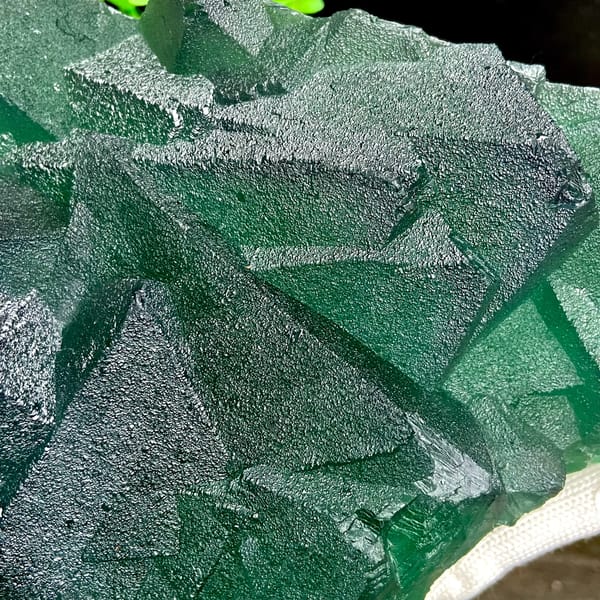 Tower of green fluorite octahedra with purple edges from Zhejiang, China, detail of the matrix contact