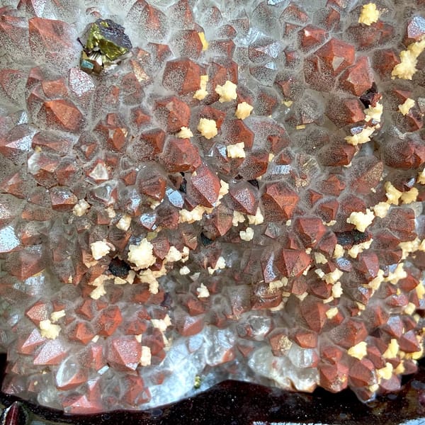 Red-skinned quartz plate with chalcopyrite and dolomite on stand from Jiangxi, China, close-up of the crystal faces