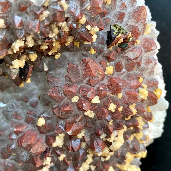 Red-skinned quartz plate with chalcopyrite and dolomite on stand from Jiangxi, China, detail of the matrix contact