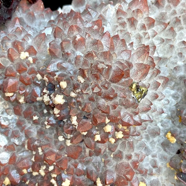 Red-skinned quartz plate with chalcopyrite and dolomite on stand from Jiangxi, China, close-up of terminations