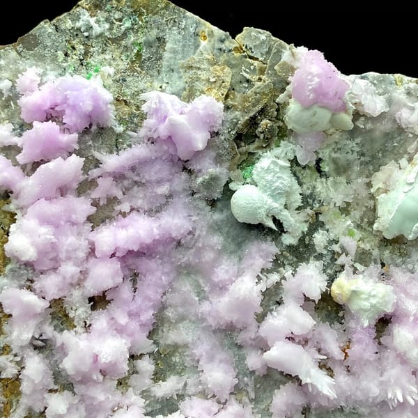 Large plate of pink aragonite crusts on tan rock from Yunnan, China, close-up of the crystal faces