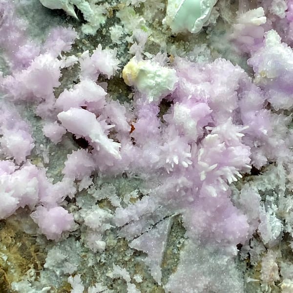 Large plate of pink aragonite crusts on tan rock from Yunnan, China, detail of the matrix contact