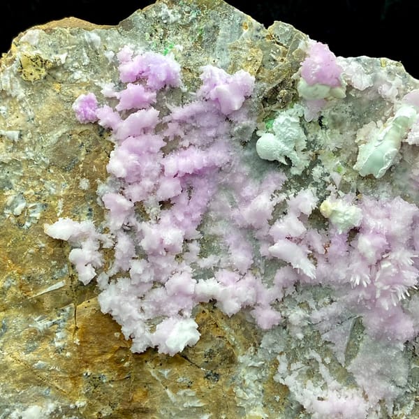 Large plate of pink aragonite crusts on tan rock from Yunnan, China, side view