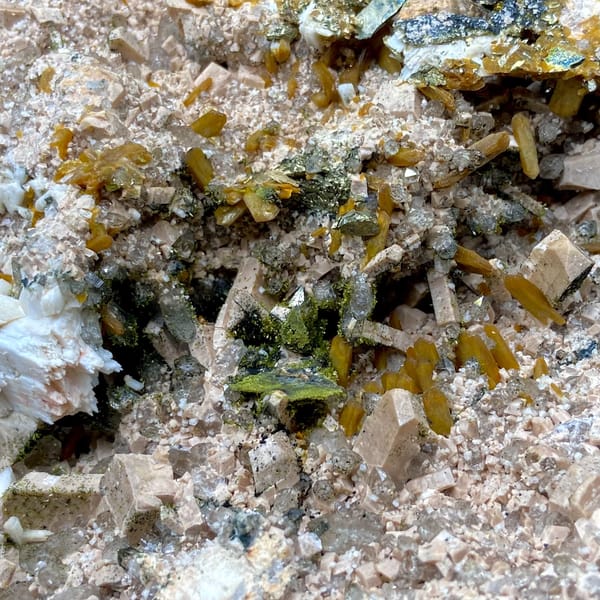 Multi-mineral plate of feldspar, zeolite, quartz, pyrite and epidote on stand from Fujian, close-up of the crystal faces
