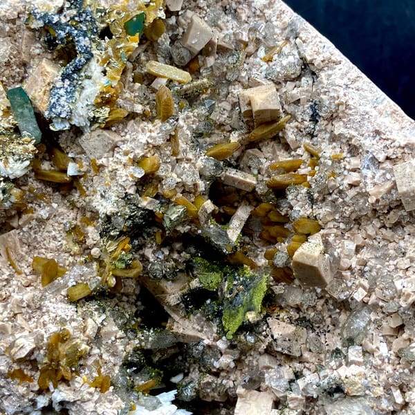 Multi-mineral plate of feldspar, zeolite, quartz, pyrite and epidote on stand from Fujian, detail of the matrix contact